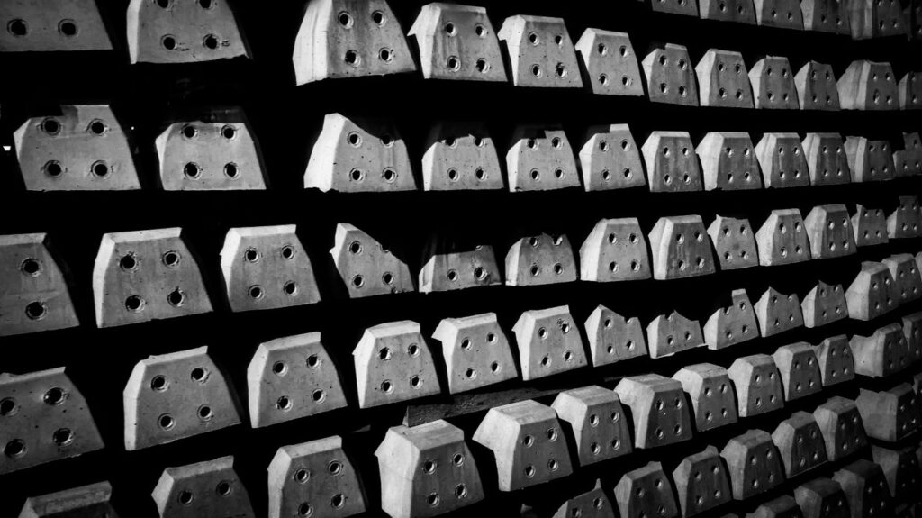 Rows of industrial concrete blocks with holes in a striking black and white pattern.